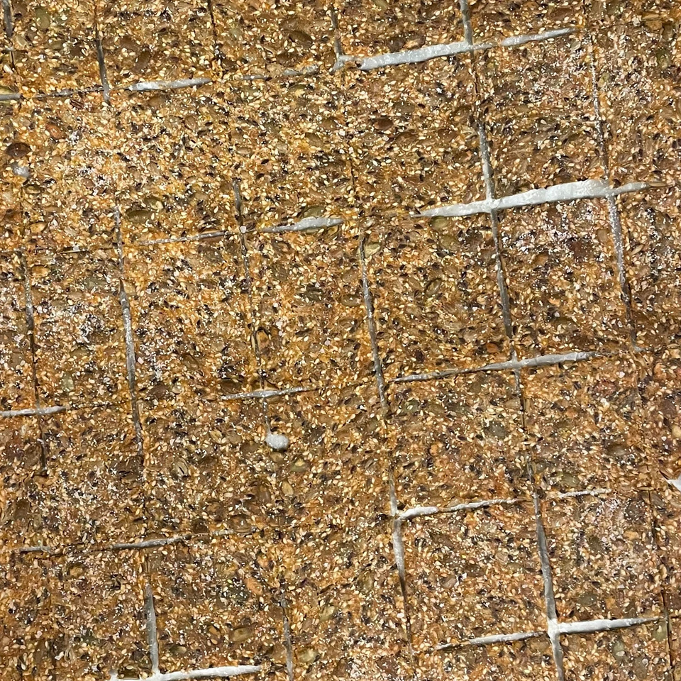 Close-up of square, seeded crackers with a light dusting of salt.